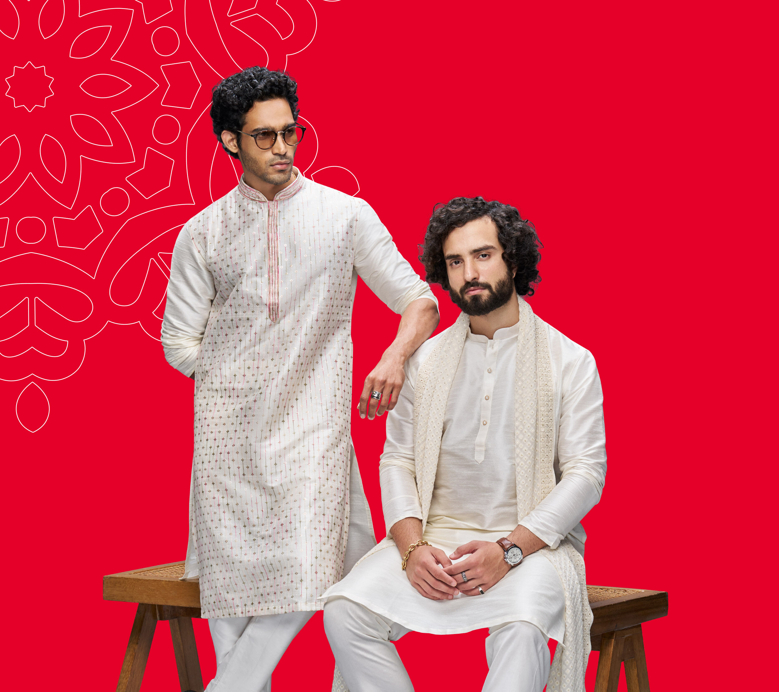 A group of young professionals celebrate Holi indoors, smiling and holding plates of colored powder with festive colors on their faces.